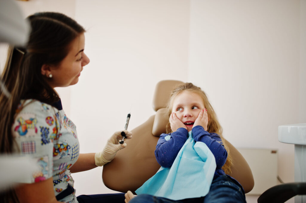 Little baby girl at dentist chair. Children dental.